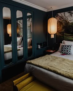 a large bed sitting in a bedroom next to two closets with mirrors on the wall