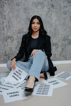 a woman sitting on the ground surrounded by papers