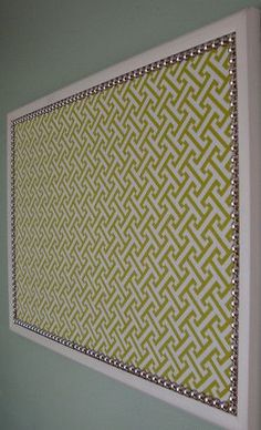 a green and white wall hanging above a toilet