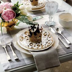 a table set with plates, silverware and flowers