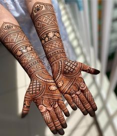 two hands with henna tattoos on them