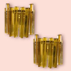 two yellow glass wall sconces against a pink background