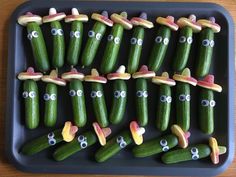 a tray filled with cucumbers covered in googly eyes