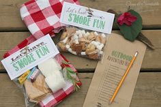 two bags of marshmallows on a picnic table next to a notepad and pencil