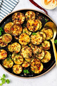 cooked zucchini on a plate with a spoon and fork next to the dish