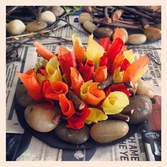 an arrangement of flowers and rocks on a newspaper