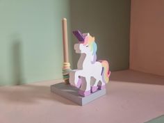 a wooden toy horse with a rainbow mane