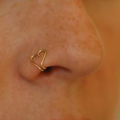 a woman's nose with a heart shaped nose ring