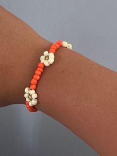 Glass bead bracelet with the colors coral white and gold. Decorated with flowers and are able to customize the color White Flower Beaded Bracelets For Beach, White Flower-shaped Bracelet With Tiny Beads, White Flower Spacer Beads, Casual White Flower Bracelets, Handmade White Stretch Bracelet With Flower Design, Handmade White Stretch Bracelet In Flower Shape, White Beaded Flower Bracelets, Casual White Flower Bracelet, White Beaded Flower-shaped Bracelet