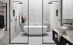 a white bath tub sitting inside of a bathroom next to a walk in shower stall