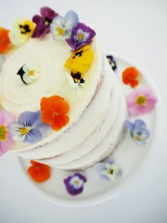 a cake with flowers on it sitting on a plate