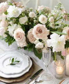 the table is set with white and pink flowers