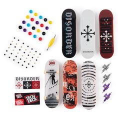 several skateboards and pins are arranged on a white surface