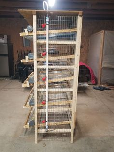 a large bird cage sitting on top of a wooden shelf in a garage next to a light