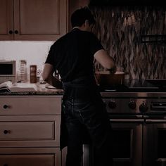 a man standing in front of a stove preparing food on top of a wooden counter