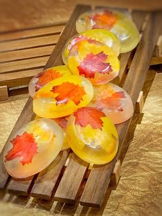 some glass plates with leaves on them are sitting on a wooden tray, ready to be used as decorations