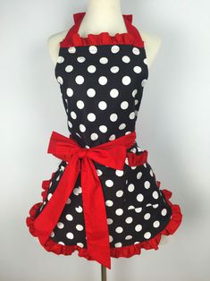 a black and white polka dot apron with red ribbon