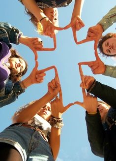 a group of people standing in a circle with their hands together to form a star