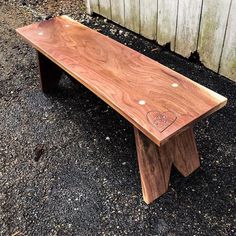 a wooden bench sitting on top of gravel