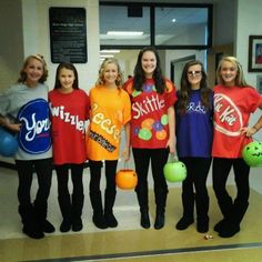 a group of women standing next to each other holding bowling balls and wearing t - shirts that say skittle