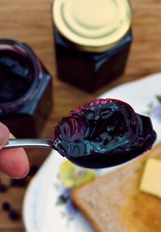 a person holding a spoon with jam on it