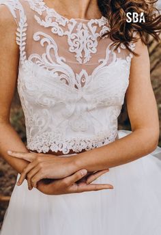 a woman in a wedding dress holding her hands together