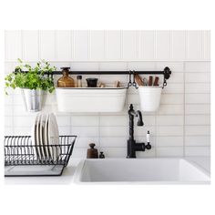 the kitchen sink is filled with dishes and utensils hanging from the wall above it