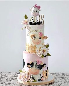 a three tiered cake decorated with farm animals and flowers on the top layer is pink, white, and gold