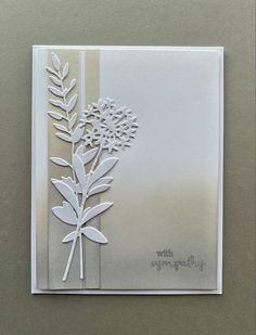 a white card with flowers and leaves on the front, it is cut out to look like