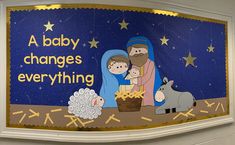 a nativity scene painted on the side of a building with an ad for baby changes everything