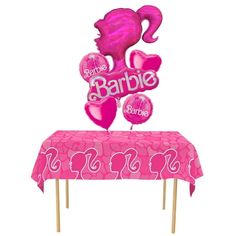 a table topped with pink balloons and a sign that says barbie on top of it