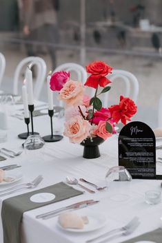 the table is set with flowers and silverware