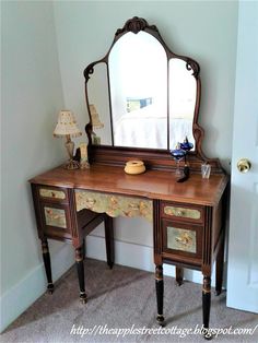 an antique dressing table with mirror and lamp