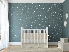 a baby's room with stars painted on the wall and crib next to it