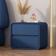 a blue side table sitting on top of a hard wood floor next to a chair