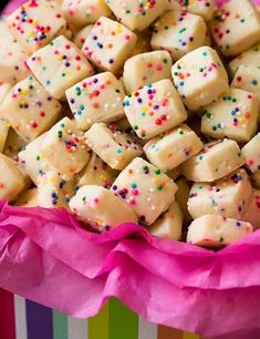 a colorful box filled with lots of white chocolate covered in sprinkles