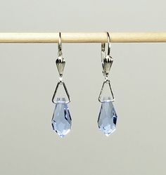 "- Preciosa Faceted Point Teardrop 13mm Crystal Earrings in stunning Light Sapphire Blue, or Baby Blue shade with 925 Sterling Silver Lever Backs in Seashell motif. See Photos #1-3. - Crystal is 3/4\" Length and 1/4\" Width and is very light. It has a Pointed end to the Crystal. - Drop Length 1 3/8\". - 925 Sterling Silver Triangular Jump Ring Connectors. - 925 Sterling Silver Lever Backs with Seashell detailing. See Photos# 1-3. - 925 Sterling Silver Bali Hook Ear Wires with tiny Ball Ends List Elegant Faceted Teardrop Earrings, Classic Drop Jewelry For Jewelry Making, White Gold Teardrop Sterling Silver Crystal Earrings, Teardrop Faceted Crystal Earrings For Formal Occasions, Faceted Teardrop Crystal Earrings For Formal Occasions, Faceted Teardrop Crystal Earrings For Formal Events, Classic Teardrop Lever Back Jewelry, Elegant Nickel-free Drop Crystal Earrings, Classic Sterling Silver Drop Earrings