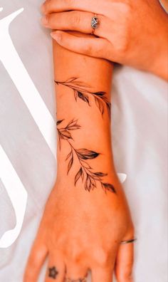 a woman's hand with tattoos on it and an arrow tattoo on the wrist