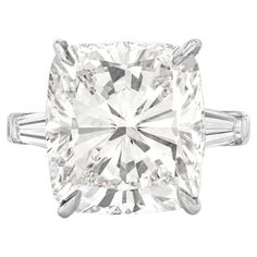 This exquisite 18k white gold ring presents a breathtaking centerpiece: a 6 carat GIA-certified Cushion briliant diamond. The diamond boasts a remarkable E color and FLAWLESS clarity, ensuring a dazzling display of brilliance and clarity. Expertly cut and symmetrical, the diamond achieves an exceptional balance of light and depth. Adding to the ring's elegance are two tapered baguette diamonds, gracefully set on each side of the main stone. These side stones enhance the ring's overall allure, dr Classic Diamond Ring, Cushion Cut Diamond Engagement Ring, Cushion Diamond Ring, Brilliant Cut Diamond Ring, Cushion Cut Diamond Ring, Contemporary Engagement Rings, Three Stone Diamond Ring, Baguette Diamond Rings, Cushion Cut Diamond