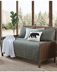 a bear pillow sitting on top of a bed in a bedroom next to a window