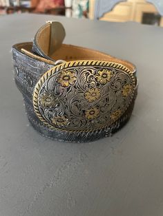 "Tony Lama Belt with silver and brass buckle| Vintage western Belt | Black patchwork leather belt | Women's western belt Women's western belt Black leather that has a patchwork design Silver tone and brass buckle bit with silver tone and brass buckle with western designed flowers 30\" long Stamped Tony Lama This is vintage so there is evidence of being worn before -- Looks like an extra hole was added along the way  Buckle can be removed and replaced for another  Buckle is 2.25\" x 3.25\"  Lots more where this came from! Check out my complete shop for more southwestern influenced jewelry and clothing !  https://sierramadrevintage.etsy.com" Womens Western Belt, Tony Lama, Western Belt, Country Concert, Western Design, Western Belts, Belt Black, Round Top, Brass Buckle