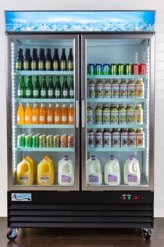 an open refrigeration unit with drinks and juices on the front door