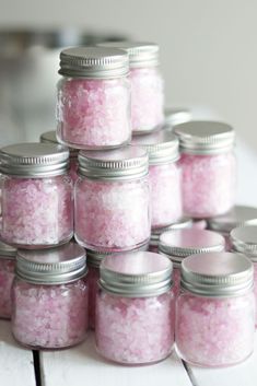 several jars filled with pink sugar sitting on top of a table