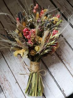 a bunch of dried flowers tied to a piece of wood