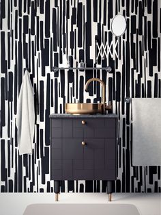 a bathroom with black and white wallpaper, gold faucet, sink and mirror