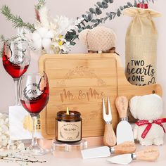 a couple of wine glasses sitting on top of a table next to bottles and spoons