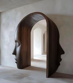 an open doorway with a wooden sculpture in the middle and a woman's head inside