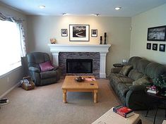 a living room with two couches and a fire place in the middle of it