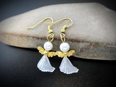 These elegant white and gold angel earrings are a lovely addition to your Christmas jewelry collection, but can also be given as a flower girl gift, confirmation or first communion gift, sympathy gift, as a baby shower gift for a new mom. They make great stocking stuffers or keep them for yourself.  Item ~ Earrings Size ~ 1 5/8 inches [41 mm] Materials ~ Hypoallergenic gold-tone brass ear wires, brass angel wing charms, glass pearls, translucent lucite bead caps Shipping ~ Ships worldwide from C White Ear Wire Earrings For Holiday, White Holiday Earrings With Ear Wire, Elegant White Earrings For Holiday, Elegant White Holiday Earrings, White Christmas Jewelry With Ear Wire, Elegant White Christmas Earrings, White Dangle Christmas Jewelry, White Christmas Jewelry With Matching Earrings, White Christmas Jewelry Set With Matching Earrings