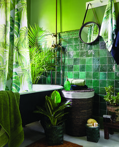 a bathroom with green tiles and plants in the tub, shower curtain, rugs